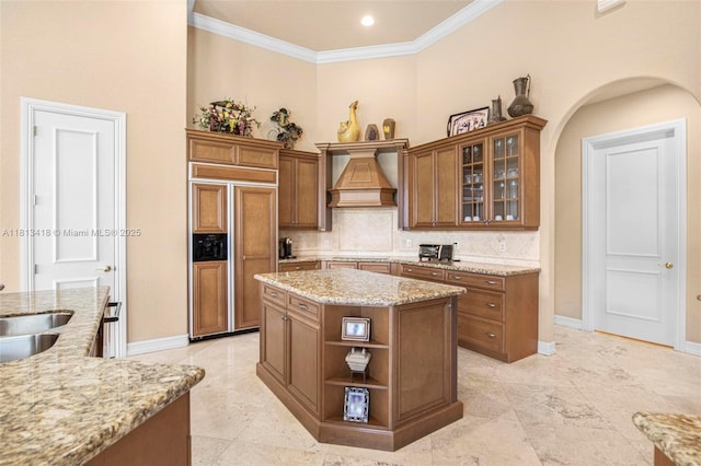 3250 W Stonebrook Cir, Davie, FL 33330 - kitchen with paneled refrigerator, custom range hood, a center island, brown cabinetry, and decorative backsplash