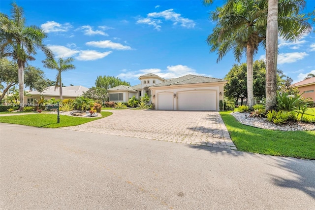 3250 W Stonebrook Cir, Davie, FL 33330 - mediterranean / spanish house featuring an attached garage, decorative driveway, stucco siding, a front lawn, and a tiled roof