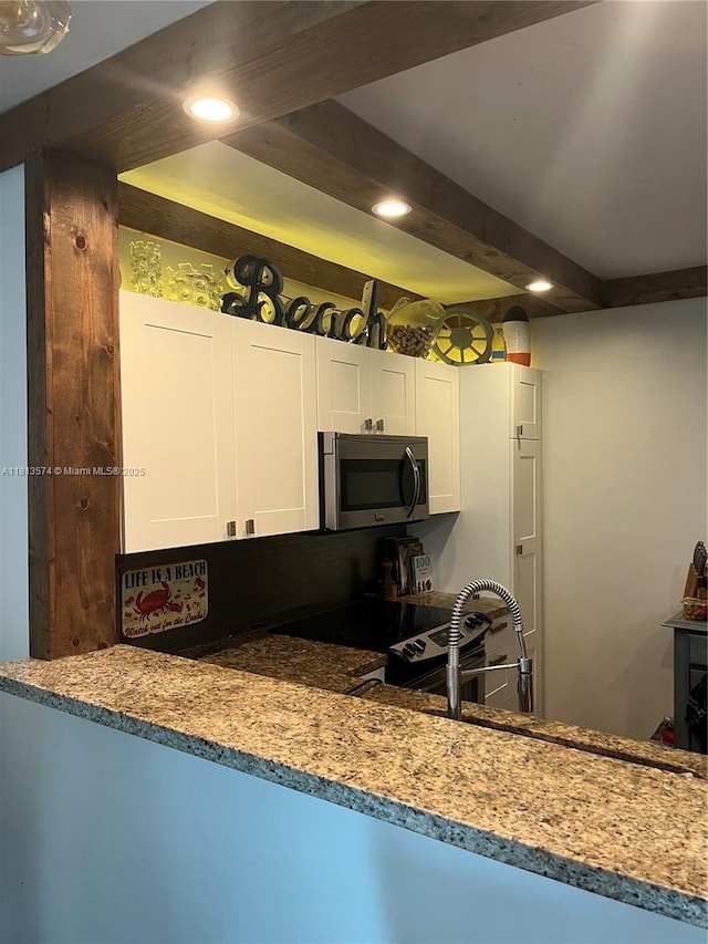 6900 Bay Dr Unit 10D, Miami Beach, FL 33141 - kitchen featuring stainless steel microwave, recessed lighting, white cabinetry, black electric range, and a sink
