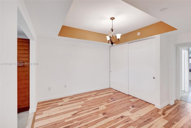 3330 NE 190th St Unit 416, Aventura, FL 33180 - empty room featuring a chandelier, light wood finished floors, and baseboards