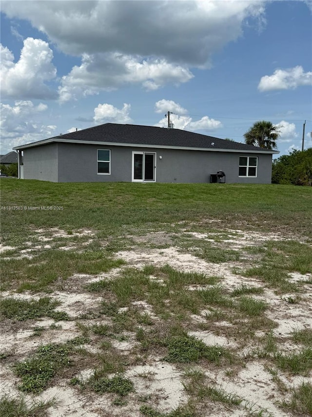 3031 Cherry Ln, La Belle, FL 33935 - back of property with stucco siding and a lawn