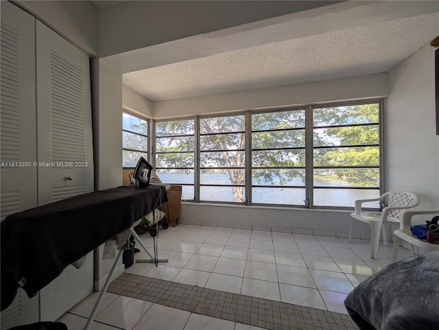 19080 NE 3rd Ct Unit 311, Miami, FL 33179 - sunroom / solarium with a water view, tile patterned floors, and a textured ceiling