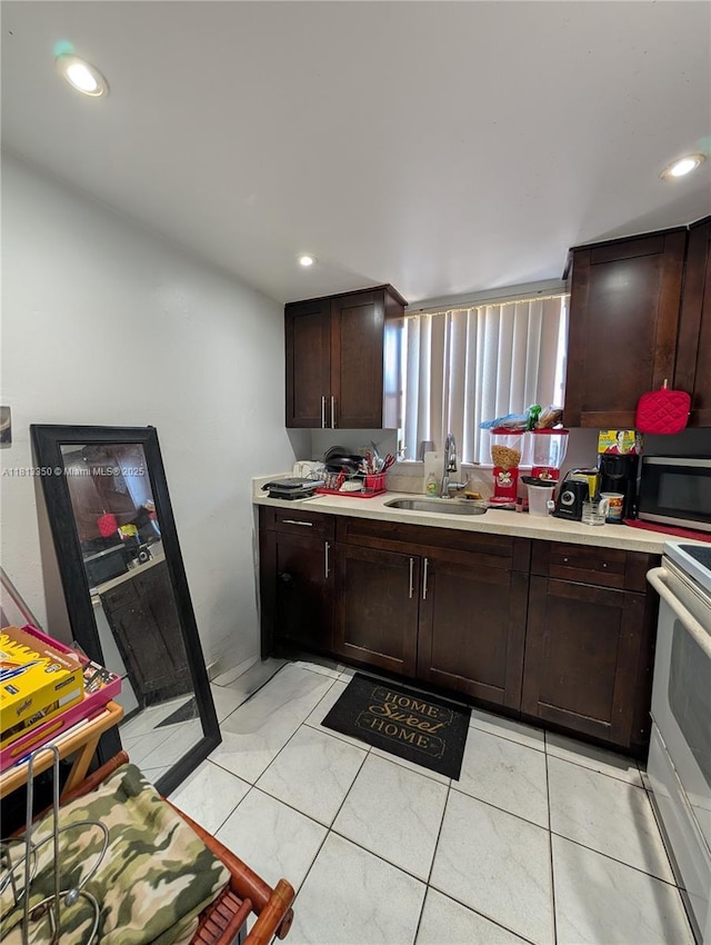 19080 NE 3rd Ct Unit 311, Miami, FL 33179 - kitchen featuring a sink, stainless steel microwave, light countertops, white electric range oven, and dark brown cabinetry