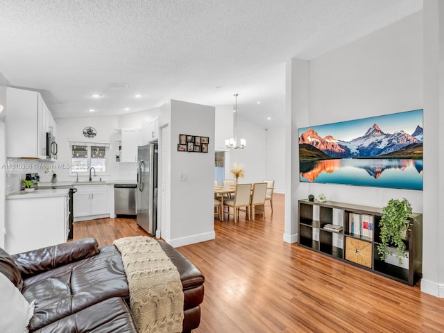 2810 River Run Cir E, Miramar, FL 33025 - living room featuring a chandelier, light wood-style floors, recessed lighting, a textured ceiling, and baseboards