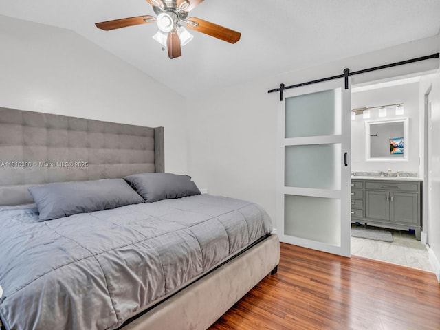 2810 River Run Cir E, Miramar, FL 33025 - bedroom featuring lofted ceiling, wood finished floors, a barn door, ceiling fan, and ensuite bathroom