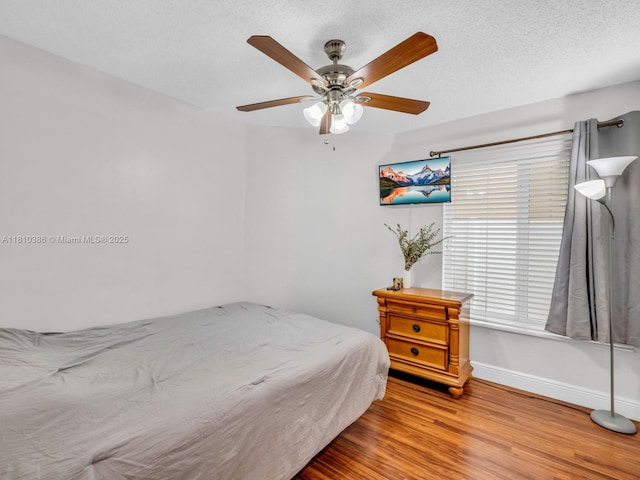2810 River Run Cir E, Miramar, FL 33025 - bedroom with baseboards, wood finished floors, a ceiling fan, and a textured ceiling