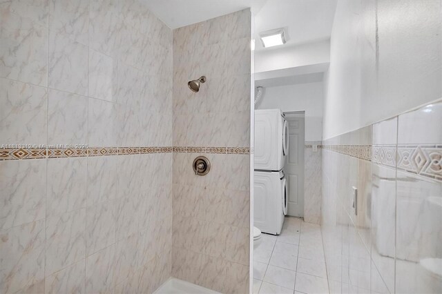 7342 Gary Ave, Miami Beach, FL 33141 - bathroom featuring tile walls, a tile shower, stacked washing machine and dryer, and tile patterned floors