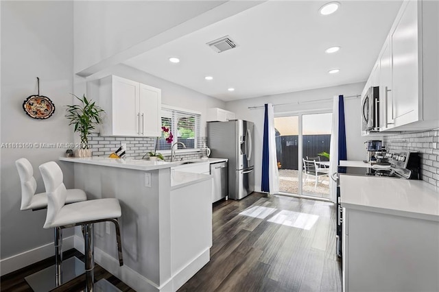 14100 Langley Pl, Davie, FL 33325 - kitchen with stainless steel appliances, a kitchen bar, healthy amount of natural light, backsplash, and recessed lighting