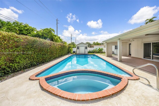 1237 Dove Ave, Miami Springs, FL 33166 - view of swimming pool with a ceiling fan, a storage unit, a patio, a fenced backyard, and a pool with connected hot tub