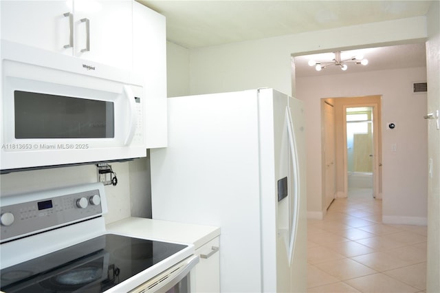 705 NE 2nd St Unit 4, Hallandale Beach, FL 33009 - kitchen featuring white appliances, light tile patterned floors, a chandelier, white cabinetry, and light countertops