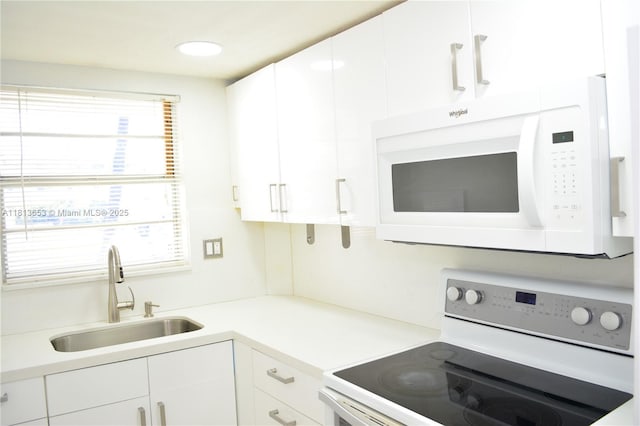 705 NE 2nd St Unit 4, Hallandale Beach, FL 33009 - kitchen featuring white microwave, electric range oven, a sink, and white cabinets