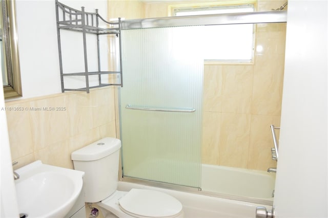 705 NE 2nd St Unit 4, Hallandale Beach, FL 33009 - full bath featuring toilet, tile walls, combined bath / shower with glass door, and a sink
