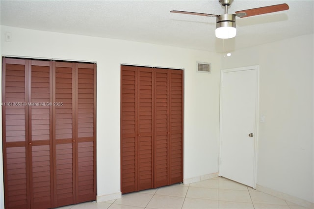 705 NE 2nd St Unit 4, Hallandale Beach, FL 33009 - unfurnished bedroom featuring two closets, light tile patterned flooring, and a ceiling fan