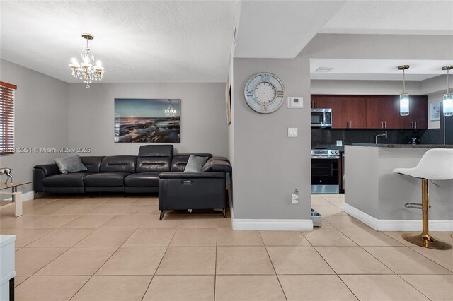 8401 SW 107th Ave Unit 117E, Miami, FL 33173 - living area featuring light tile patterned flooring, a chandelier, and baseboards