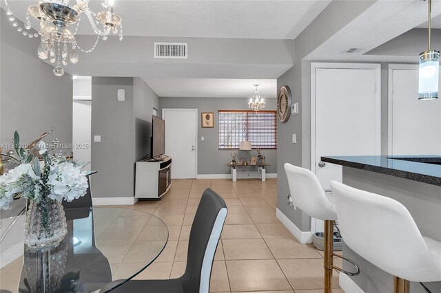 8401 SW 107th Ave Unit 117E, Miami, FL 33173 - dining area featuring a chandelier, baseboards, and light tile patterned flooring
