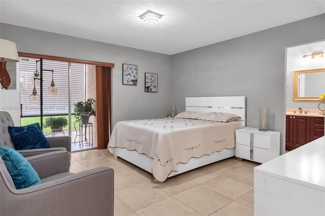 8401 SW 107th Ave Unit 117E, Miami, FL 33173 - bedroom featuring access to outside, light tile patterned floors, ensuite bath, and a textured ceiling