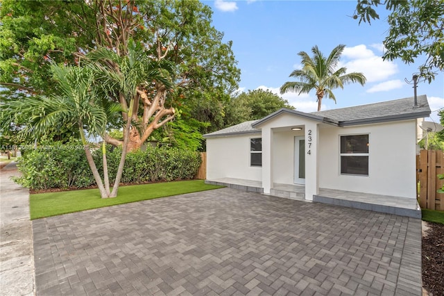 2374 NW 56th St, Miami, FL 33142 - ranch-style house with stucco siding, a patio area, and a shingled roof