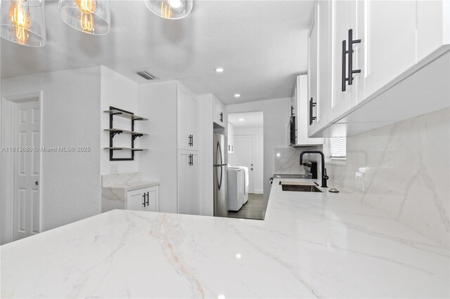 2374 NW 56th St, Miami, FL 33142 - kitchen with freestanding refrigerator, white cabinetry, light stone counters, open shelves, and recessed lighting