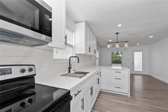 2374 NW 56th St, Miami, FL 33142 - kitchen featuring stainless steel appliances, a sink, white cabinets, a peninsula, and recessed lighting