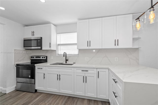 2374 NW 56th St, Miami, FL 33142 - kitchen featuring stainless steel appliances, a sink, wood finished floors, tasteful backsplash, and white cabinets