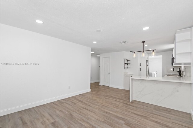 2374 NW 56th St, Miami, FL 33142 - unfurnished living room featuring a sink, light wood-style flooring, recessed lighting, and baseboards