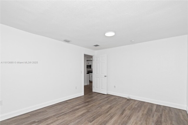 2374 NW 56th St, Miami, FL 33142 - empty room featuring wood finished floors and baseboards