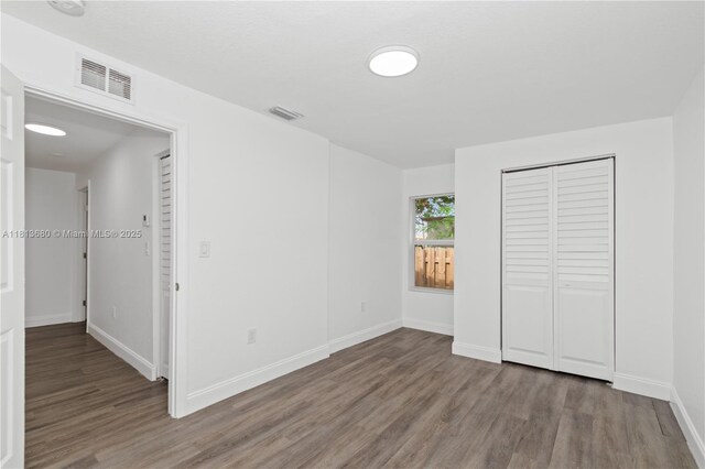2374 NW 56th St, Miami, FL 33142 - unfurnished bedroom with wood finished floors, baseboards, and a closet