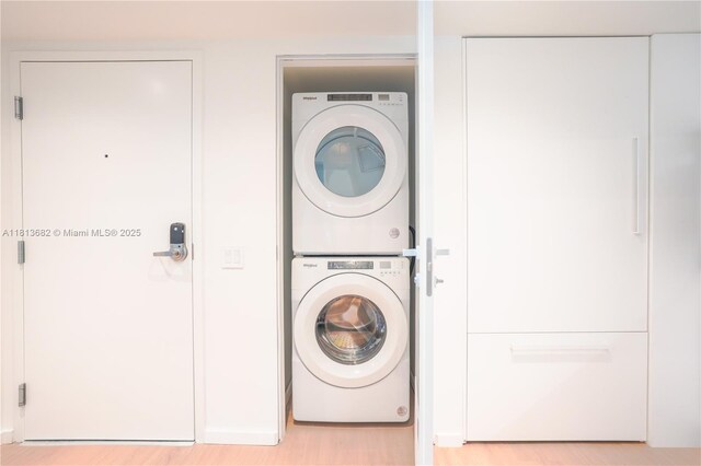 10250 Collins Ave Unit Ph1, Bal Harbour, FL 33154 - washroom featuring stacked washing machine and dryer and light wood-style flooring