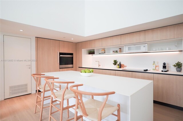 10250 Collins Ave Unit Ph1, Bal Harbour, FL 33154 - kitchen featuring stainless steel oven, open shelves, light brown cabinetry, modern cabinets, and recessed lighting