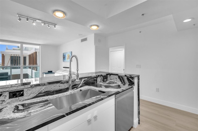 347 N New River Dr E Unit 1205, Fort Lauderdale, FL 33301 - kitchen featuring stainless steel dishwasher, a sink, light wood-style flooring, white cabinetry, and dark stone counters
