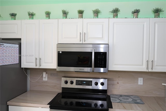 20816 NW 2nd St, Pembroke Pines, FL 33029 - kitchen featuring appliances with stainless steel finishes, decorative backsplash, white cabinetry, and light countertops