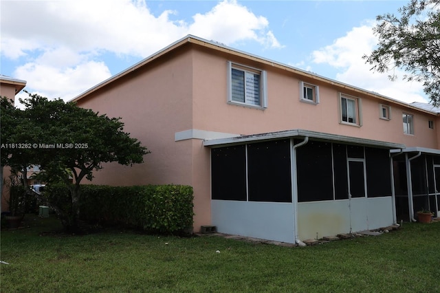 20816 NW 2nd St, Pembroke Pines, FL 33029 - rear view of house with stucco siding, a sunroom, and a yard