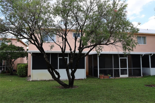 20816 NW 2nd St, Pembroke Pines, FL 33029 - back of house featuring a sunroom, a yard, and stucco siding