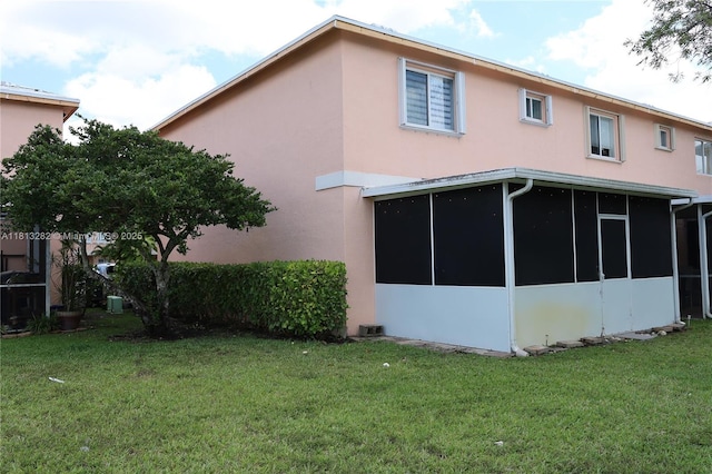 20816 NW 2nd St, Pembroke Pines, FL 33029 - back of house featuring stucco siding, a lawn, and a sunroom