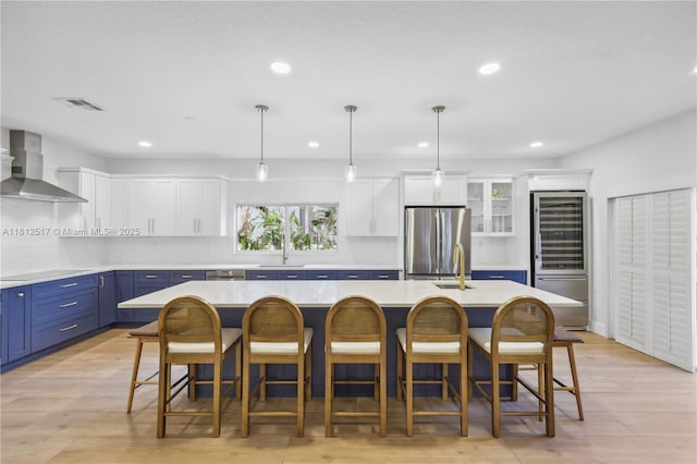 3229 Canal Dr, Pompano Beach, FL 33062 - kitchen with wall chimney range hood, blue cabinets, appliances with stainless steel finishes, recessed lighting, and white cabinets