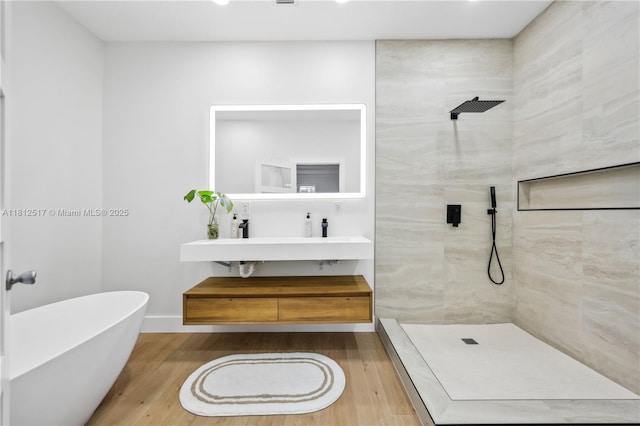 3229 Canal Dr, Pompano Beach, FL 33062 - bathroom with tiled shower, wood finished floors, double vanity, recessed lighting, and a freestanding bath