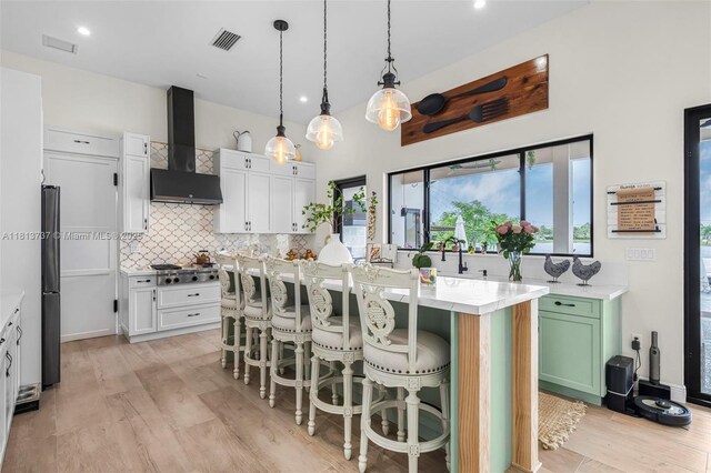 9291 SW 88th St, Miami, FL 33176 - kitchen with light wood-type flooring, a breakfast bar, a fireplace, a center island, and white cabinets