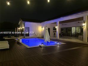 9291 SW 88th St, Miami, FL 33176 - pool at night featuring a hot tub and a deck