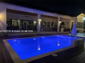9291 SW 88th St, Miami, FL 33176 - pool at night featuring a hot tub, an outdoor pool, and a ceiling fan