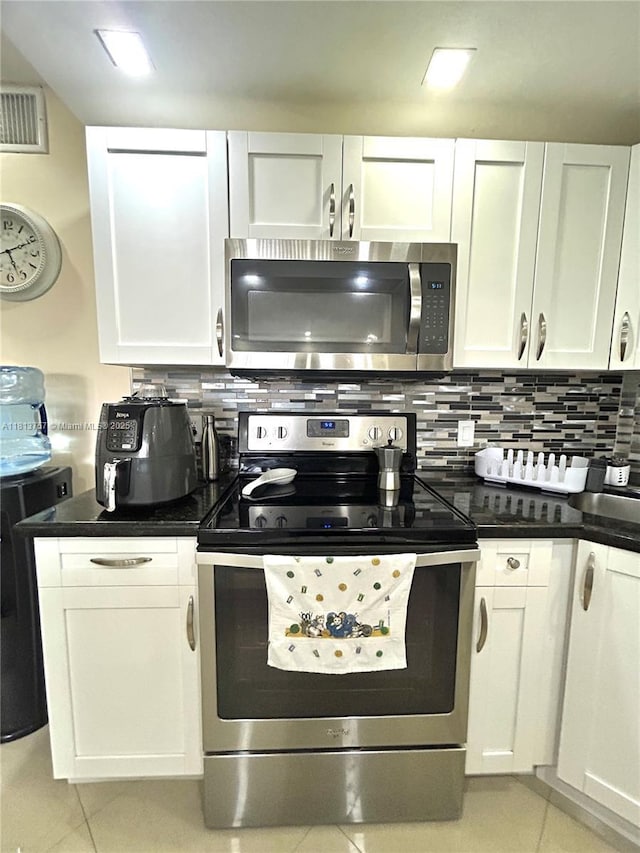3200 NE 7th Ct Unit 306C, Pompano Beach, FL 33062 - kitchen featuring stainless steel appliances, light tile patterned floors, white cabinetry, and decorative backsplash