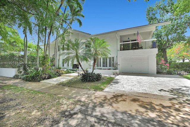 1450 Ortega Ave, Coral Gables, FL 33134 - view of front facade with stucco siding, a balcony, driveway, and a garage