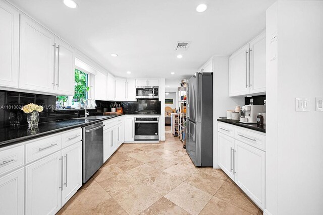 1450 Ortega Ave, Coral Gables, FL 33134 - kitchen with appliances with stainless steel finishes, a sink, backsplash, dark countertops, and white cabinets