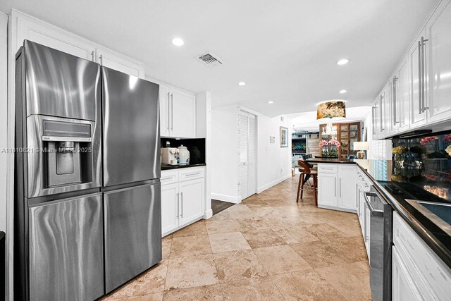 1450 Ortega Ave, Coral Gables, FL 33134 - kitchen with stainless steel fridge, white cabinets, dark countertops, decorative backsplash, and recessed lighting