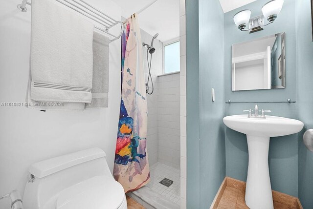 1450 Ortega Ave, Coral Gables, FL 33134 - bathroom featuring toilet, tiled shower, and tile patterned flooring