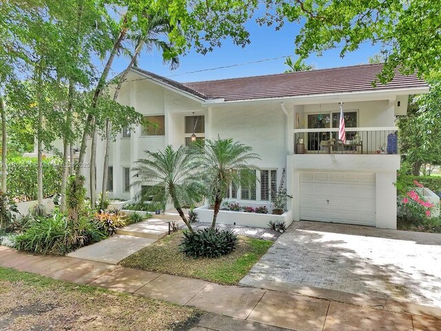 1450 Ortega Ave, Coral Gables, FL 33134 - view of front facade with stucco siding, driveway, a tile roof, and an attached garage