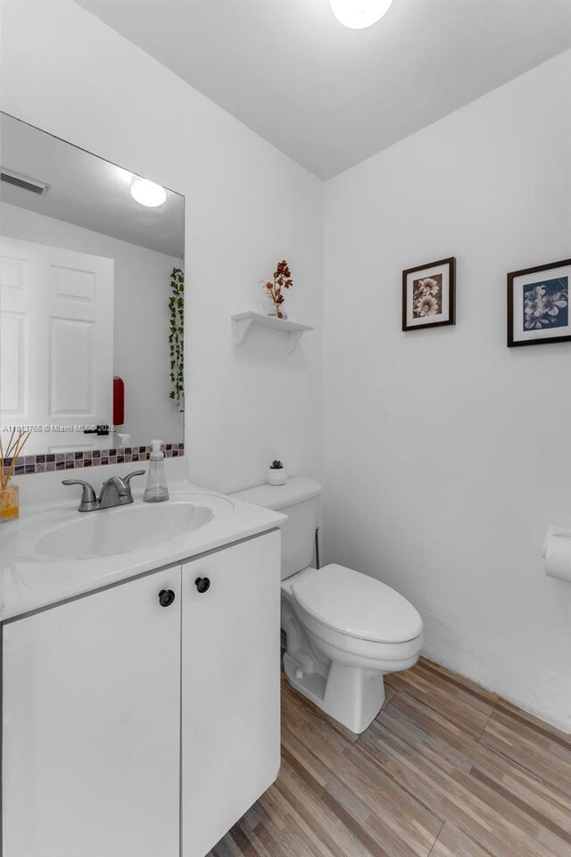 14011 SW 151st Ave, Miami, FL 33196 - half bathroom featuring vanity, toilet, wood finished floors, and decorative backsplash
