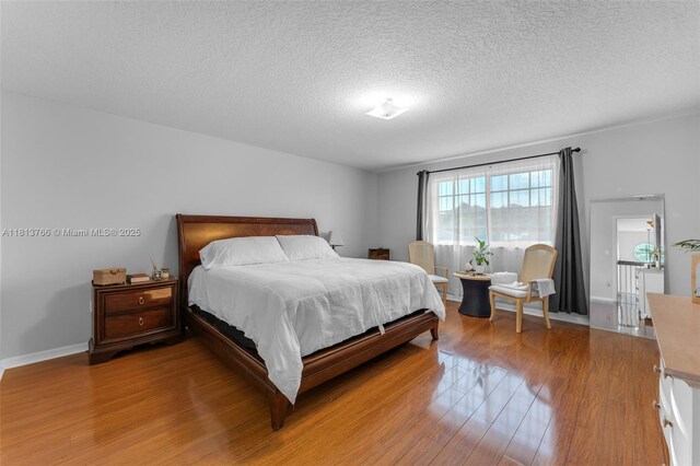 14011 SW 151st Ave, Miami, FL 33196 - bedroom featuring wood finished floors, a textured ceiling, and baseboards