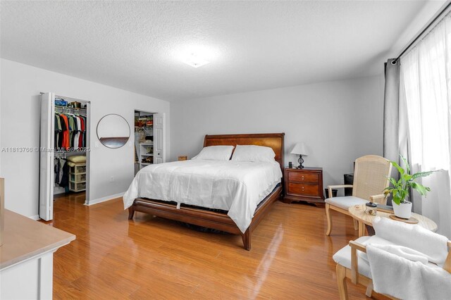 14011 SW 151st Ave, Miami, FL 33196 - bedroom with a spacious closet, light wood finished floors, a textured ceiling, a closet, and baseboards