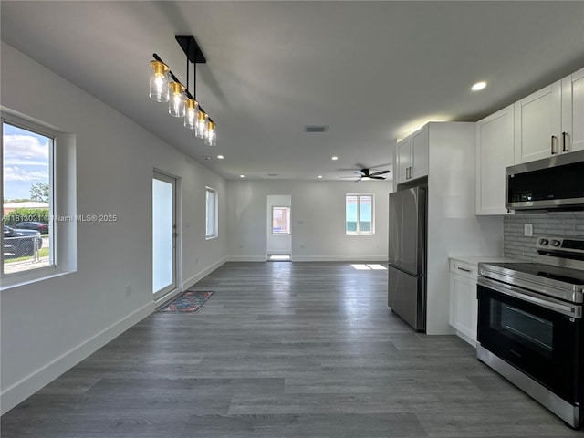 5450 SW 6th St, Miami, FL 33134 - kitchen featuring stainless steel appliances, open floor plan, recessed lighting, white cabinets, and wood finished floors