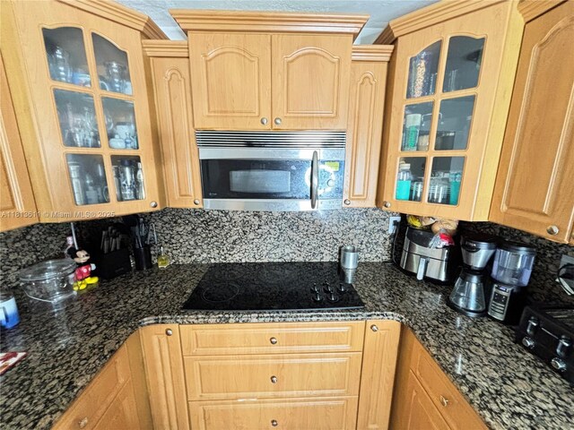 6907 SW 22nd Ct, Miramar, FL 33023 - kitchen featuring stainless steel microwave, black electric stovetop, light brown cabinetry, and backsplash